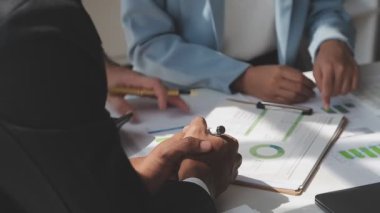 İş adamları modern ofisteki bir toplantıda mali raporu tartışıyor