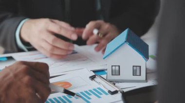 Mimarlar ve tasarımcılar modern bir ofiste bir yapı modeline odaklanmakla ve inşaat ve planlama üzerine çalışmakla meşguller..