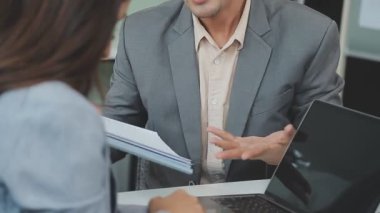 Bir takım ortamında finansal verileri ve pazarlama performans grafiklerini tartışan ve analiz eden iş uzmanları, kârlılığın artması için stratejik planlamaya odaklanıyorlar..