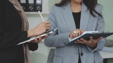 Bir takım ortamında finansal verileri ve pazarlama performans grafiklerini tartışan ve analiz eden iş uzmanları, kârlılığın artması için stratejik planlamaya odaklanıyorlar..