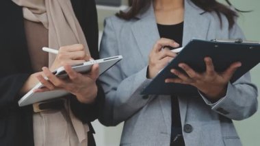 Bir takım ortamında finansal verileri ve pazarlama performans grafiklerini tartışan ve analiz eden iş uzmanları, kârlılığın artması için stratejik planlamaya odaklanıyorlar..