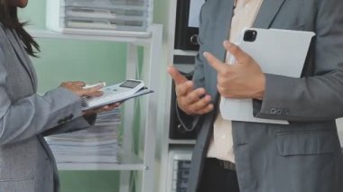 Bir takım ortamında finansal verileri ve pazarlama performans grafiklerini tartışan ve analiz eden iş uzmanları, kârlılığın artması için stratejik planlamaya odaklanıyorlar..