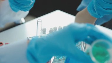 Bir grup genç araştırmacı çağdaş bir laboratuvar ortamında yeni bir aşı geliştirmeye odaklanmış durumda.