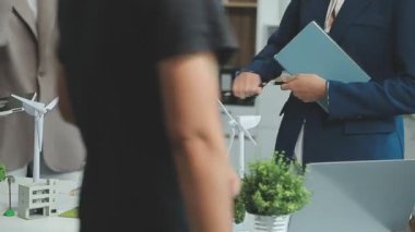 Bir grup profesyonelin çevre dostu ve temiz enerji ürünleri pazarlama stratejilerini tartıştığı yeşil işletme toplantısı.