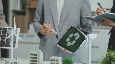 Bir grup profesyonelin çevre dostu ve temiz enerji ürünleri pazarlama stratejilerini tartıştığı yeşil işletme toplantısı.