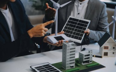 İki Genç Mühendis Güneş Hücresi Kurulum Toplantısı ve İş Tartışması Uzmanı. Ofis Odası 'nda Fabrika İnşaat Planlı Çatı Üzerine Güneş Fotovoltaik Panelleri Kurmayı Planlıyorum.