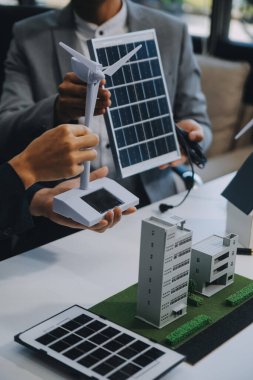 İki Genç Mühendis Güneş Hücresi Kurulum Toplantısı ve İş Tartışması Uzmanı. Ofis Odası 'nda Fabrika İnşaat Planlı Çatı Üzerine Güneş Fotovoltaik Panelleri Kurmayı Planlıyorum.