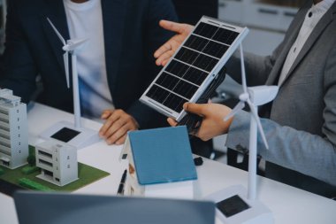 İki Genç Mühendis Güneş Hücresi Kurulum Toplantısı ve İş Tartışması Uzmanı. Ofis Odası 'nda Fabrika İnşaat Planlı Çatı Üzerine Güneş Fotovoltaik Panelleri Kurmayı Planlıyorum.