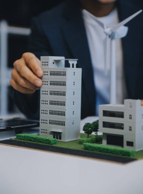 İki Genç Mühendis Güneş Hücresi Kurulum Toplantısı ve İş Tartışması Uzmanı. Ofis Odası 'nda Fabrika İnşaat Planlı Çatı Üzerine Güneş Fotovoltaik Panelleri Kurmayı Planlıyorum.