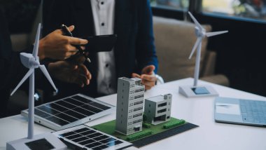 İki Genç Mühendis Güneş Hücresi Kurulum Toplantısı ve İş Tartışması Uzmanı. Ofis Odası 'nda Fabrika İnşaat Planlı Çatı Üzerine Güneş Fotovoltaik Panelleri Kurmayı Planlıyorum.