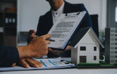 Emlakçı ev satın alma anlaşmasının şartları hakkında konuştu ve müşteriden sözleşmeyi yasal hale getirmek için belgeleri imzalamasını istedi, ev satışları ve ev sigortası kavramı.