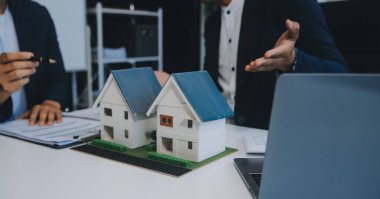 Emlakçı ev satın alma anlaşmasının şartları hakkında konuştu ve müşteriden sözleşmeyi yasal hale getirmek için belgeleri imzalamasını istedi, ev satışları ve ev sigortası kavramı.