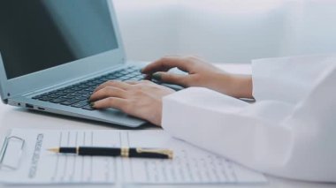 Beyaz önlüklü genç doktor ofiste çalışıyor.