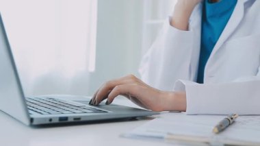 Ofiste dizüstü bilgisayarda çalışan kadın doktor..