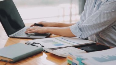 Modern ofiste belgelerle çalışan genç iş kadını, hızlı iş ve finans dünyasını yansıtıyor..