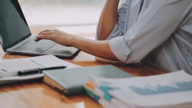 Genç bir iş kadını, bir iş ve finans temasını yansıtan çağdaş ofis ortamında çalışmalarına odaklanmış..