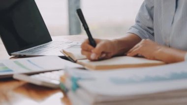 Modern ofiste belgelerle çalışan genç iş kadını, hızlı iş ve finans dünyasını yansıtıyor..