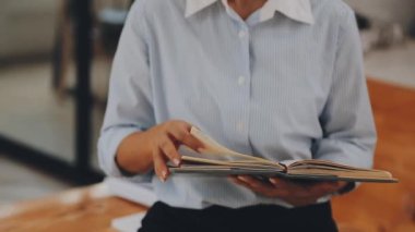 Genç bir iş kadını, bir iş ve finans temasını yansıtan çağdaş ofis ortamında çalışmalarına odaklanmış..