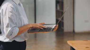 Genç bir iş kadını, bir iş ve finans temasını yansıtan çağdaş ofis ortamında çalışmalarına odaklanmış..