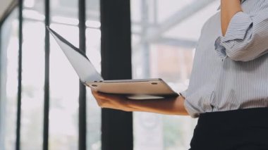 Genç bir iş kadını, bir iş ve finans temasını yansıtan çağdaş ofis ortamında çalışmalarına odaklanmış..