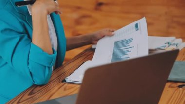 Çekici Asyalı iş kadını ofiste oturuyor, rapor hazırlıyor Gelir İdaresi 'nin belgelerini kontrol ediyor..