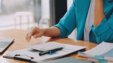 Çekici Asyalı iş kadını ofiste oturuyor, rapor hazırlıyor Gelir İdaresi 'nin belgelerini kontrol ediyor..