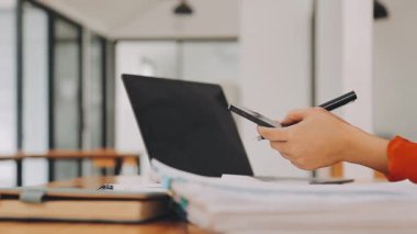 Çekici Asyalı iş kadını ofiste oturuyor, rapor hazırlıyor Gelir İdaresi 'nin belgelerini kontrol ediyor..