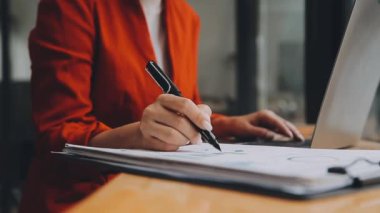 Çekici Asyalı iş kadını ofiste oturuyor, rapor hazırlıyor Gelir İdaresi 'nin belgelerini kontrol ediyor..