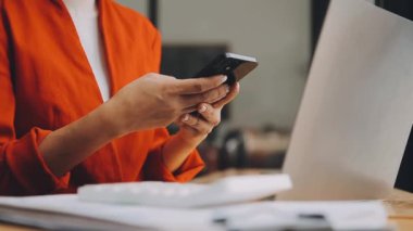 Şık bir ofiste cep telefonu kullanan genç bir iş kadını, hızlı iş ve finans dünyasını yansıtıyor..