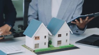 Çağdaş bir ofiste mimarlar ve tasarımcılar bir yapı modeli üzerinde çalışıyor ve inşaat ve kentsel planlama için fikirler geliştiriyorlar..