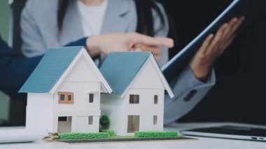 Çağdaş bir ofiste mimarlar ve tasarımcılar bir yapı modeli üzerinde çalışıyor ve inşaat ve kentsel planlama için fikirler geliştiriyorlar..