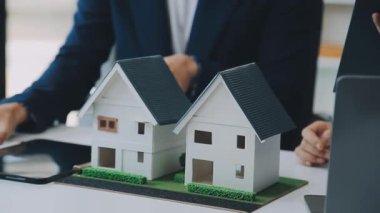 Mimarlar modern bir ofiste bir yapı modeli üzerinde işbirliği yaparken, tasarımcılar inşaat, geliştirme, kentsel planlama, proje yönetimi ve yaratıcı fikirlerle ilgili mimari kavramlar geliştirmeye odaklanıyor.