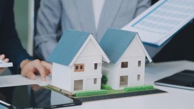 Mimarlar modern bir ofiste bir yapı modeli üzerinde işbirliği yaparken, tasarımcılar inşaat, geliştirme, kentsel planlama, proje yönetimi ve yaratıcı fikirlerle ilgili mimari kavramlar geliştirmeye odaklanıyor.