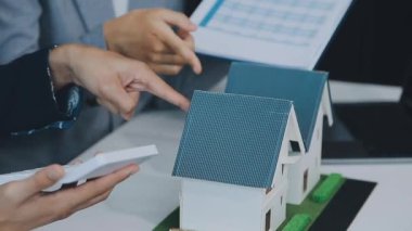 Mimarlar modern bir ofiste bir yapı modeli üzerinde işbirliği yaparken, tasarımcılar inşaat, geliştirme, kentsel planlama, proje yönetimi ve yaratıcı fikirlerle ilgili mimari kavramlar geliştirmeye odaklanıyor.