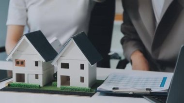 Mimarlar modern bir ofiste bir yapı modeli üzerinde işbirliği yaparken, tasarımcılar inşaat, geliştirme, kentsel planlama, proje yönetimi ve yaratıcı fikirlerle ilgili mimari kavramlar geliştirmeye odaklanıyor.