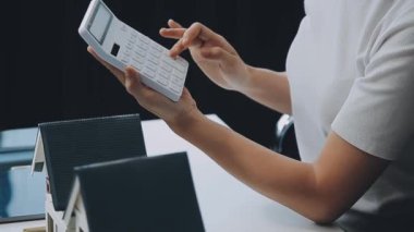Mimarlar modern bir ofiste bir yapı modeli üzerinde işbirliği yaparken, tasarımcılar inşaat, geliştirme, kentsel planlama, proje yönetimi ve yaratıcı fikirlerle ilgili mimari kavramlar geliştirmeye odaklanıyor.