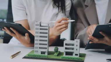 Mimarlar modern ofiste bir bina modeli üzerinde çalışıyorlar. Tasarımcı mimariyi geliştiriyor. İnşaat, geliştirme, kentsel planlama, proje yönetimi ve yaratıcı fikir.
