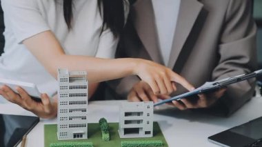 Mimarlar modern ofiste bir bina modeli üzerinde çalışıyorlar. Tasarımcı mimariyi geliştiriyor. İnşaat, geliştirme, kentsel planlama, proje yönetimi ve yaratıcı fikir.