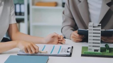 Mimarlar modern bir ofiste bir yapı modeli üzerinde işbirliği yaparken, tasarımcılar inşaat, geliştirme, kentsel planlama, proje yönetimi ve yaratıcı fikirlerle ilgili mimari kavramlar geliştirmeye odaklanıyor.