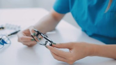 Gözlüklü kadın doktor steteskop tutuyor.