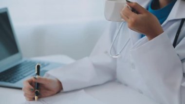 Doktor, bir dizüstü bilgisayar ve iş arkadaşıyla ofiste çalışıyor..