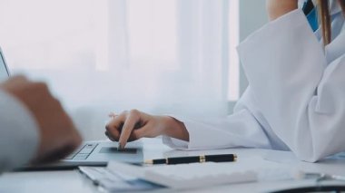 Dişçi, modern klinikteki bir hastayla diş sorunlarını tartışıyor.