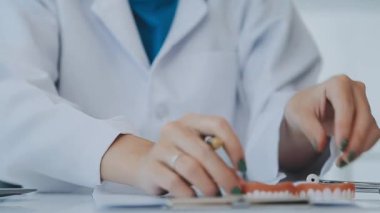 Dişçi, modern klinikteki bir hastayla diş sorunlarını tartışıyor.