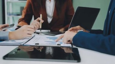 Genç profesyoneller, iş ve finans bağlamında modern bir ofiste ortak bir çalışma oturumuna katıldılar.