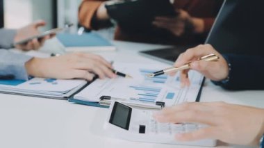 Genç profesyoneller, iş ve finans bağlamında modern bir ofiste ortak bir çalışma oturumuna katıldılar.