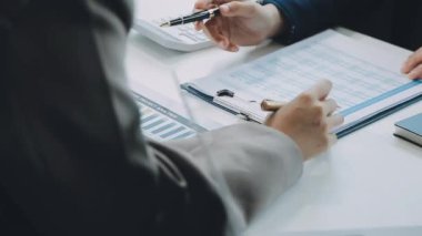 Genç profesyoneller, iş ve finans bağlamında modern bir ofiste ortak bir çalışma oturumuna katıldılar.