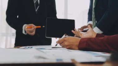 Genç profesyoneller, iş ve finans bağlamında modern bir ofiste ortak bir çalışma oturumuna katıldılar.