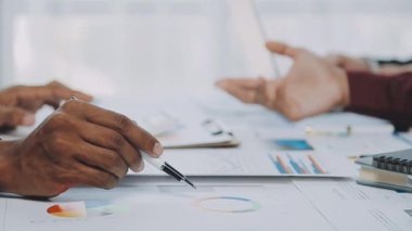 Genç girişimciler, iş ve finans kavramlarını somutlaştıran çağdaş bir ofiste birlikte çalışıyorlar..