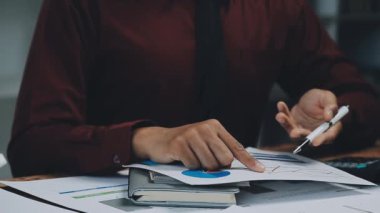 Genç Asyalı işadamı, ofisteki dizüstü bilgisayarla finansal verileri analiz ediyor. muhasebe işi kavramı