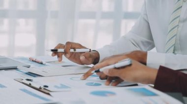 Genç girişimciler, iş ve finansman odaklı modern bir ofis alanında birlikte çalışıyorlar.